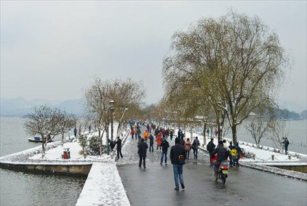 Tourists wonder by West Lake after snowfall in China's Hangzhou
